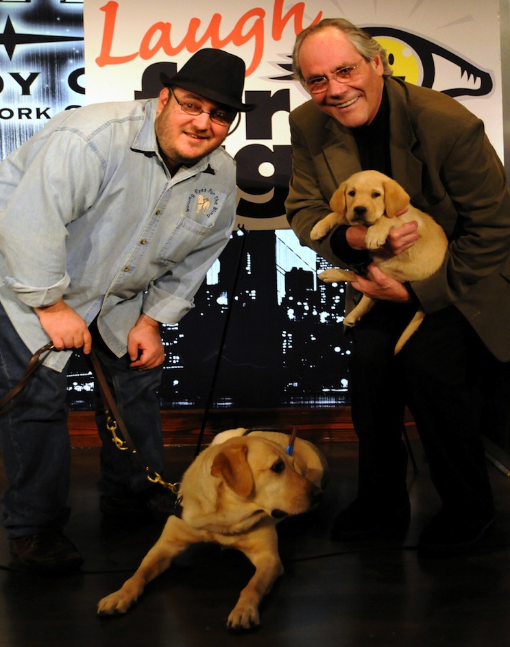 Photo of Brian Fischler with his guide dog Nash and Robert Klein with a Guiding Eyes for the Blind puppy in training